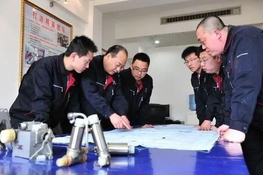 △李志強(qiáng)（左二）與班組成員在研究工作。