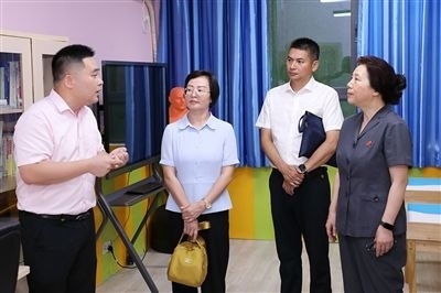 圖③：“小公民法律課堂”開講前，全國(guó)人大代表殷其龍（右二）、重慶市人大代表李自玲（左二）聽取楊家坪中學(xué)負(fù)責(zé)人關(guān)于未成年人思想教育工作情況的介紹。