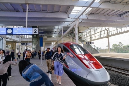  10月17日，在印度尼西亞萬隆德卡魯爾站，乘客在站臺上和雅萬高鐵高速動車組列車合影。新華社記者 徐欽 攝
