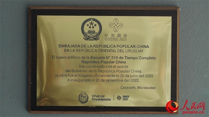 小學墻上懸掛的中國援助標識。人民網(wǎng)記者 張若涵攝