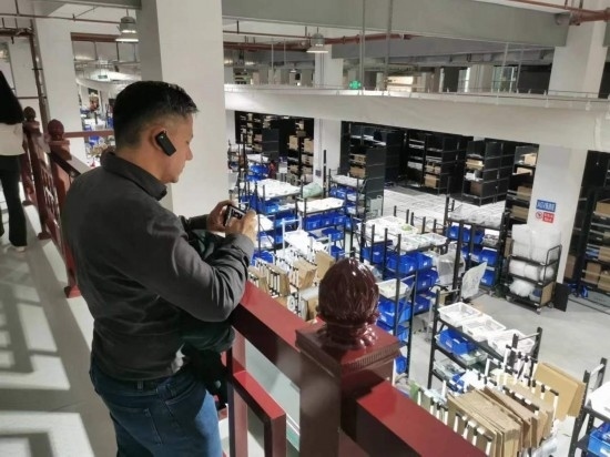 2023“一帶一路”媒體合作論壇聯(lián)合采訪團(tuán)團(tuán)員在仁和醫(yī)藥物流園拍攝記錄轉(zhuǎn)運(yùn)流程。（本報(bào)記者 黃超攝）