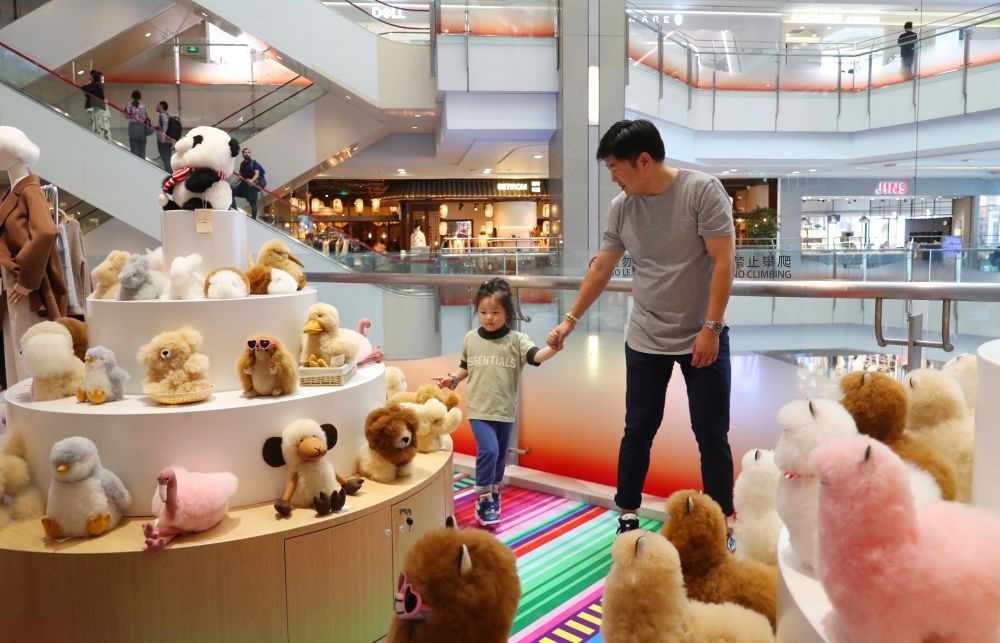 2023年11月2日，顧客在溫暖駝品牌專柜內(nèi)選購。連續(xù)六年參加進(jìn)博會(huì)的秘魯羊駝制品品牌溫暖駝在上海市中心商場開設(shè)了專柜。新華社記者 方喆 攝