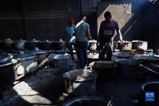 11月3日，在加沙地帶南部城市拉法，人們?cè)诿簹庵袛嗪笥貌窕鹱鲲?。新華社發(fā)（里澤克·阿卜杜勒賈瓦德攝）