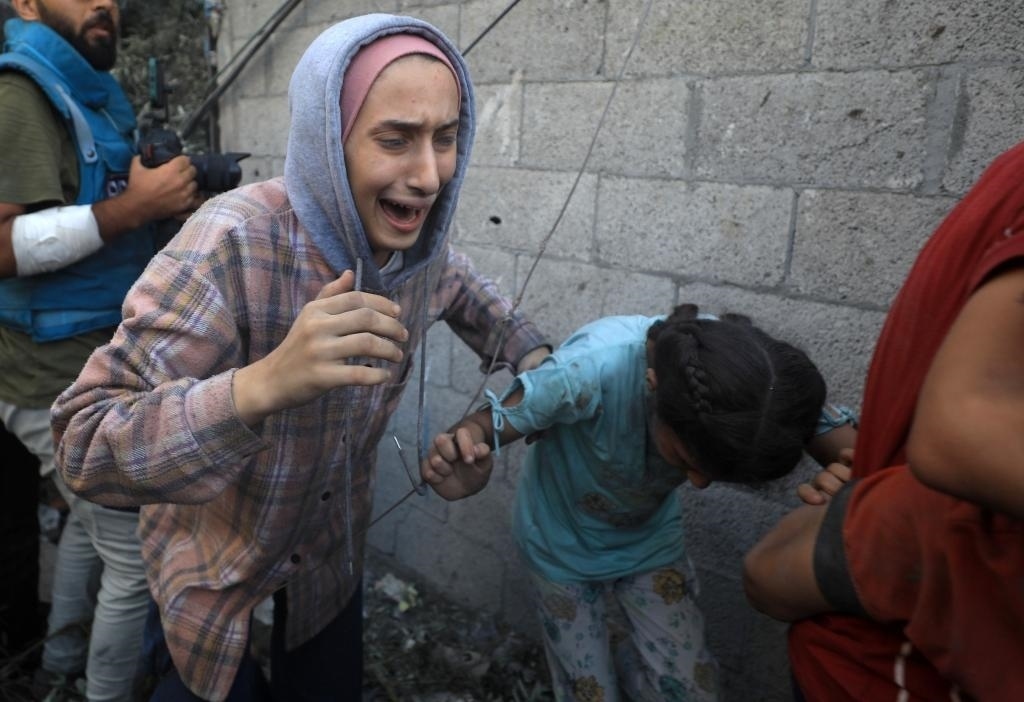 11月6日，人們從加沙地帶中部地區(qū)一處被炸難民營逃離。新華社發(fā)（亞西爾·庫迪攝）