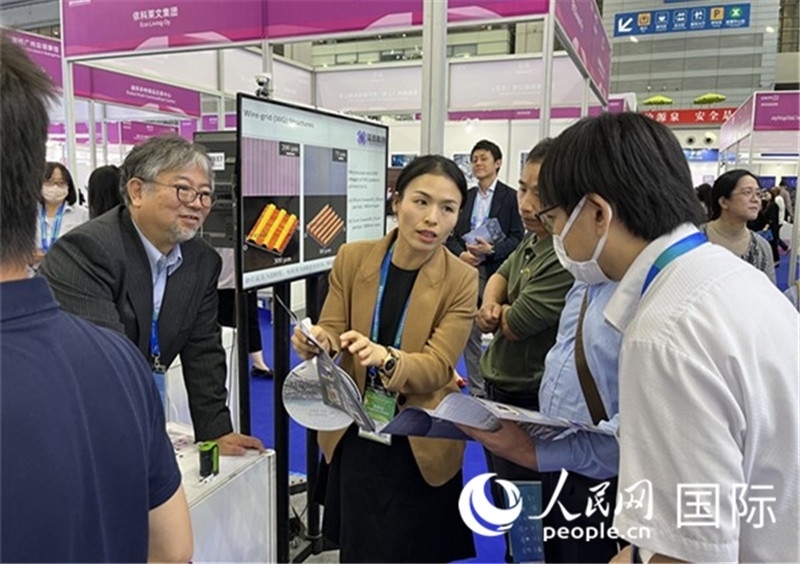 工作人員向參觀者介紹超級(jí)噴墨技術(shù)。（人民網(wǎng)記者 陳思攝）