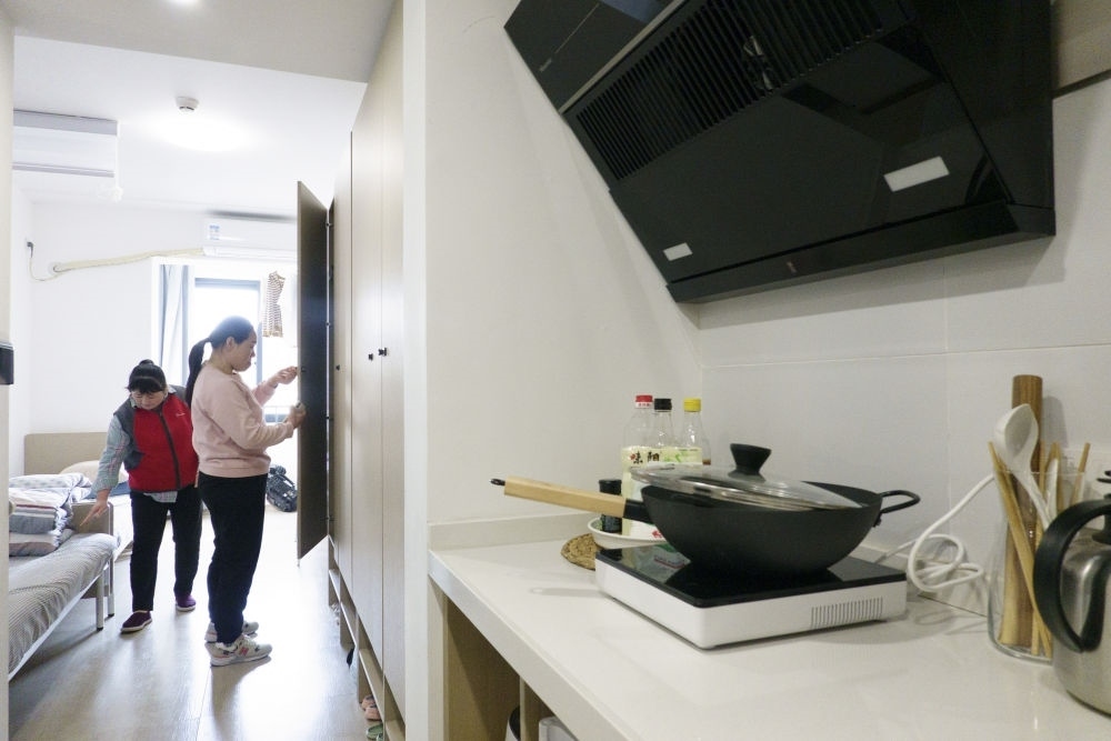 住戶在閔行區(qū)新時代城市建設者管理者之家收拾房間。