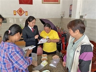  圖⑤：龍圩區(qū)法院法官到群眾家中開展法治宣傳。資料圖片