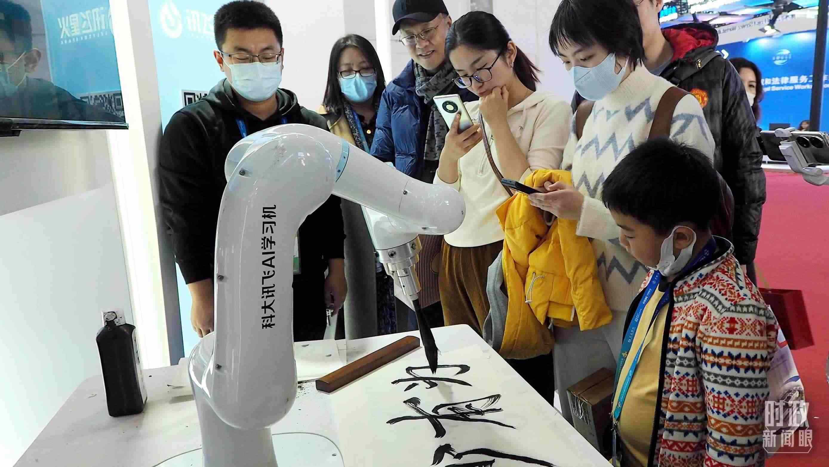 △觀眾在首屆鏈博會(huì)上體驗(yàn)AI書法機(jī)器人。