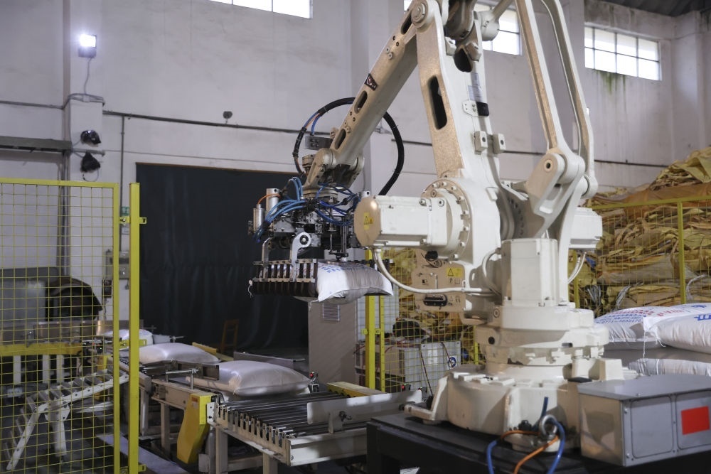 12月14日，在廣西來賓東糖鳳凰有限公司，機械臂在廠房碼放白砂糖成品。