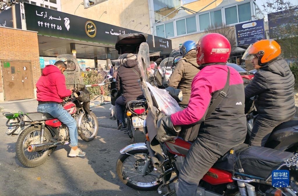 12月18日，摩托車在伊朗首都德黑蘭的一家加油站外等待加油。新華社記者 沙達(dá)提 攝