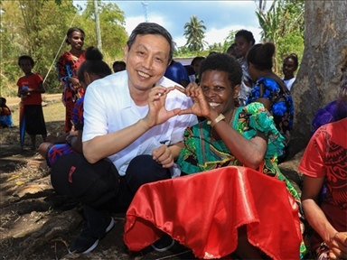 2023年12月18日，中國駐瓦努阿圖大使李名剛和前來觀看瓦努阿圖公路項(xiàng)目二期馬勒庫拉段移交儀式的當(dāng)?shù)鼐用窈嫌?。人民網(wǎng) 賀吉攝