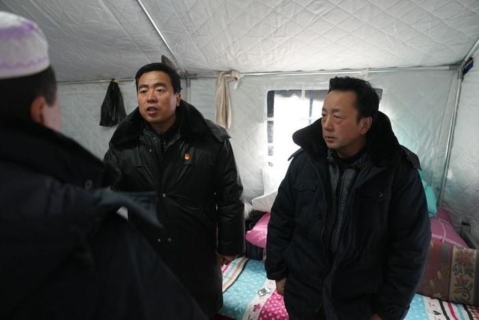 2023年12月22日，積石山縣大河家鎮(zhèn)大河村黨支部書記馬成忠（右二）在帳篷里和受災群眾交流。新華社記者 陳斌 攝