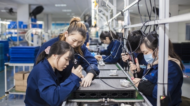 在新亞勝光電的產(chǎn)品線上，工人正進(jìn)行產(chǎn)品組建和安裝布線。受訪者供圖