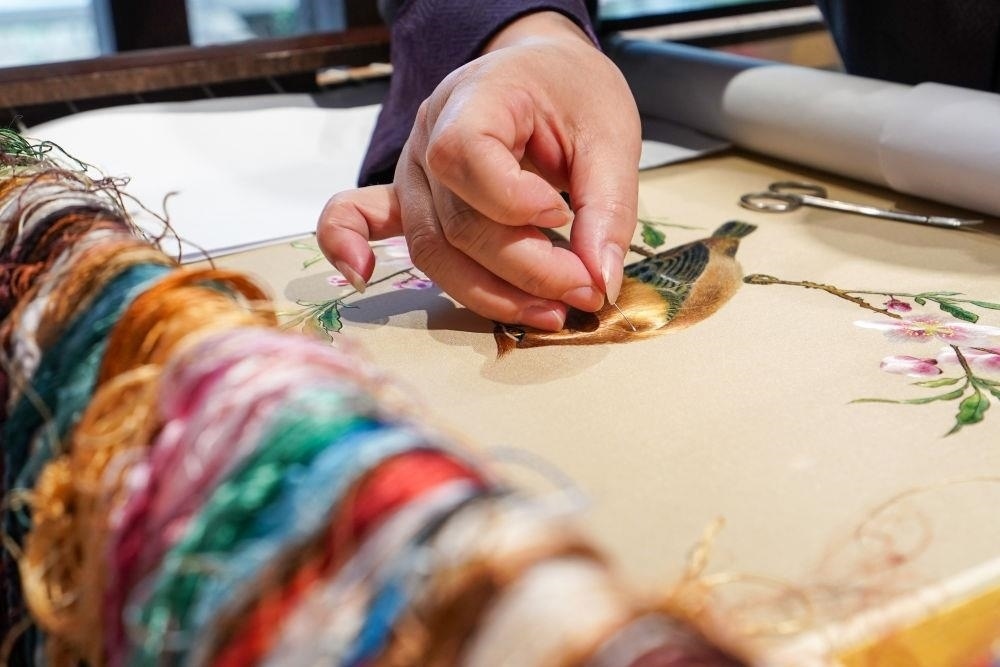 △2023年7月6日，盧建英在江蘇蘇州平江路的工作室內(nèi)刺繡。