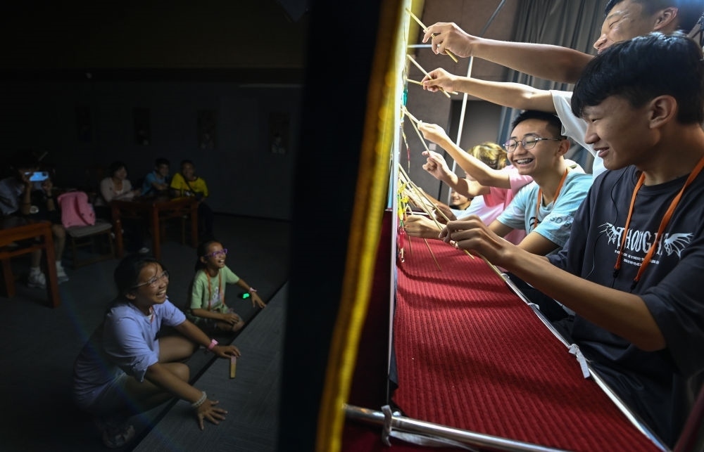 2023年8月8日，進(jìn)行暑期研學(xué)的學(xué)生在位于陜西省西安市的中國(guó)秦腔藝術(shù)博物館體驗(yàn)皮影戲演出。新華社記者 鄒競(jìng)一 攝