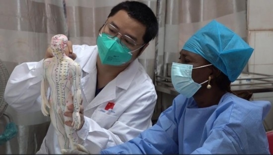 嘉興市中醫(yī)醫(yī)院郝亞波給當地助手講解中醫(yī)經絡。新華社發(fā)