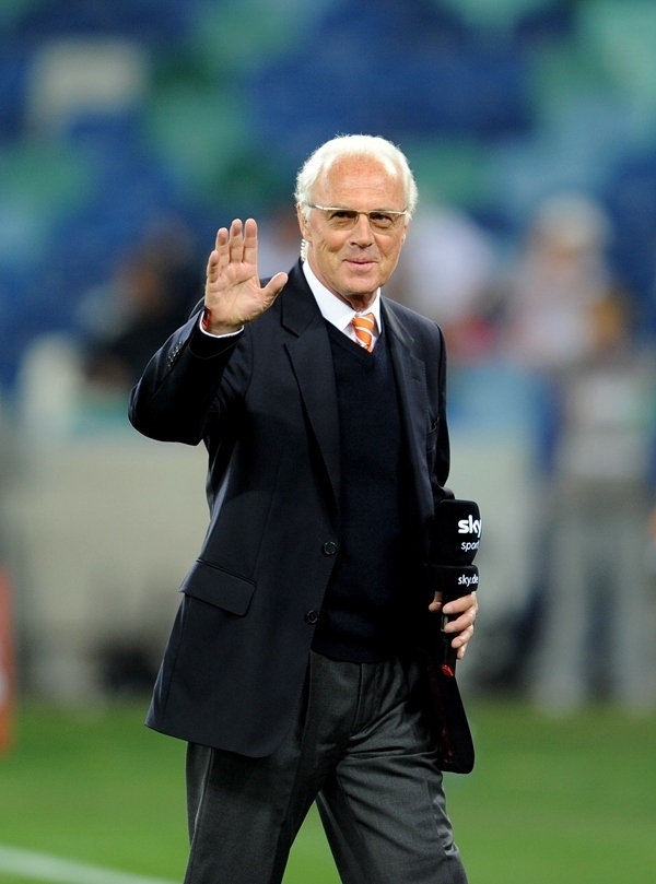 這是2010年7月7日，在南非德班舉行的2010年足球世界杯德國隊(duì)對陣西班牙隊(duì)的半決賽前，貝肯鮑爾接受電視臺(tái)采訪時(shí)和友人打招呼。新華社記者 王毓國 攝