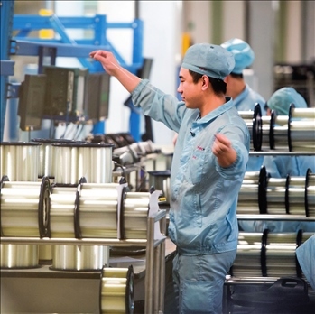 在位于武漢的長飛光纖光纜股份有限公司光纖生產(chǎn)車間內(nèi)，工作人員對光纖進(jìn)行檢測（資料圖片）。肖藝九攝/本刊