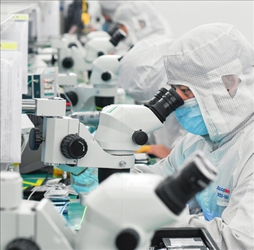 在位于武漢中國光谷的光電器件研發(fā)制造商——武漢光迅科技股份有限公司生產(chǎn)車間內(nèi)，技術(shù)人員在光模塊生產(chǎn)線作業(yè)（2023年4月11日攝）。程敏攝/本刊