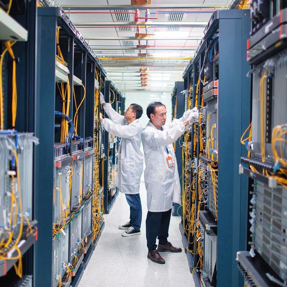 在位于武漢中國光谷的光電器件研發(fā)制造商——武漢光迅科技股份有限公司生產(chǎn)車間內(nèi)，技術(shù)人員在光模塊生產(chǎn)線作業(yè)（2023年4月11日攝）。程敏攝/本刊