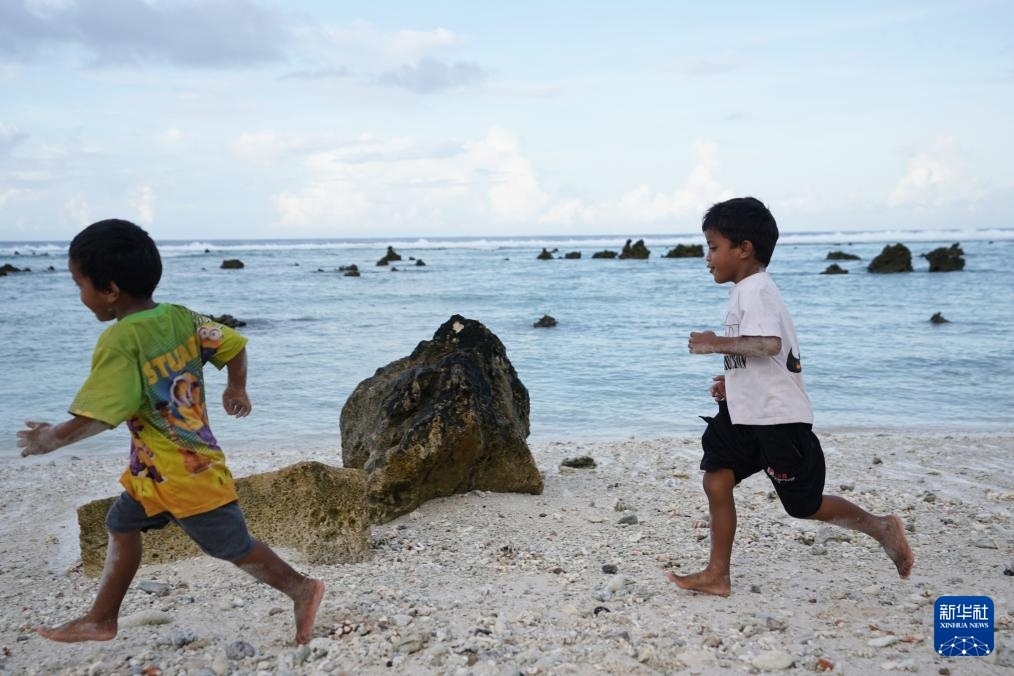 1月20日，兒童在瑙魯海邊嬉戲。新華社記者 王申 攝