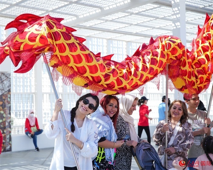 游客體驗舞龍。 人民網(wǎng) 塔里克·易卜拉欣攝