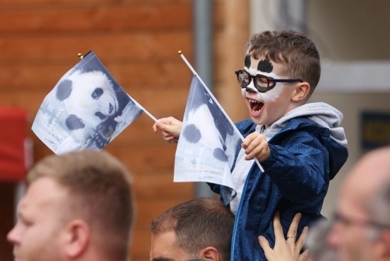  2023年7月26日，在法國(guó)圣艾尼昂市博瓦勒野生動(dòng)物園外，一名兒童等待送別熊貓“圓夢(mèng)”。新華社記者 高靜 攝