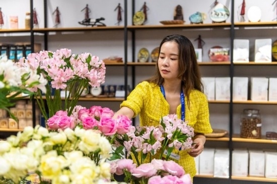 2023年7月1日，在位于湖南省長沙市的湖南高橋大市場，中非經(jīng)貿(mào)博覽會常設展館展區(qū)肯尼亞館工作人員在整理產(chǎn)自非洲的鮮花。新華社記者 陳思汗 攝