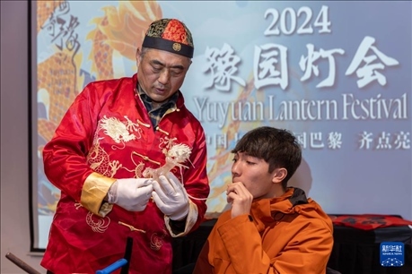 1月28日，在上海豫園舉行的民俗活動上，美國馬斯卡廷中學(xué)學(xué)生在非遺傳承人的指導(dǎo)下吹糖偶。 新華社記者 王翔 攝