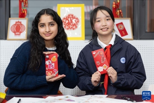 1月28日，美國馬斯卡廷中學(xué)學(xué)生（左）和復(fù)旦大學(xué)第二附屬學(xué)校學(xué)生展示互相送出的寫有寄語祝福的紅包。 新華社記者 王翔 攝