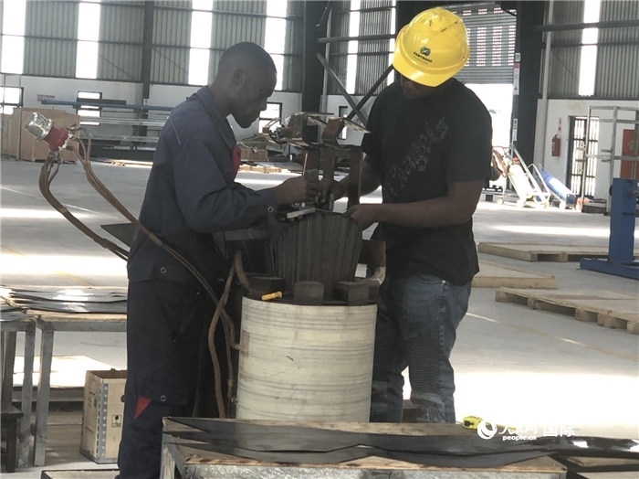 經(jīng)貿(mào)合作區(qū)廠房內(nèi)，當?shù)毓と苏诰o張作業(yè)。人民網(wǎng)記者 黃培昭攝