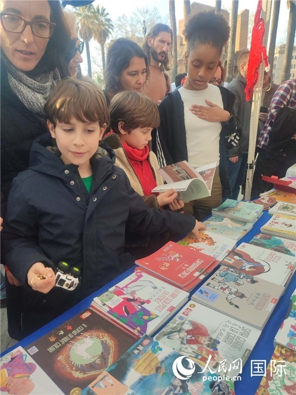 印刷精美的中國(guó)傳統(tǒng)文化叢書(shū)吸引了小游客的注意。人民網(wǎng)記者鄭彬攝