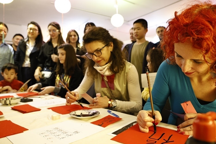 羅馬尼亞觀眾學(xué)習(xí)用毛筆寫“?！弊?。中國文化中心供圖