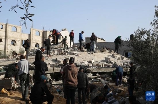  3月3日，在加沙地帶南部城市拉法，人們查看被以軍空襲破壞的建筑。新華社發(fā)（哈立德·奧馬爾攝）