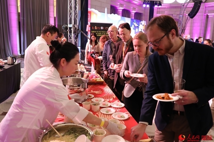 當(dāng)?shù)貢r間3月7日晚，華盛頓聯(lián)合車站廣場舉行駐美使團“使館主廚挑戰(zhàn)賽”。圖為當(dāng)?shù)孛癖娫谥袊古_前體驗中國美食。人民網(wǎng)記者 李志偉攝