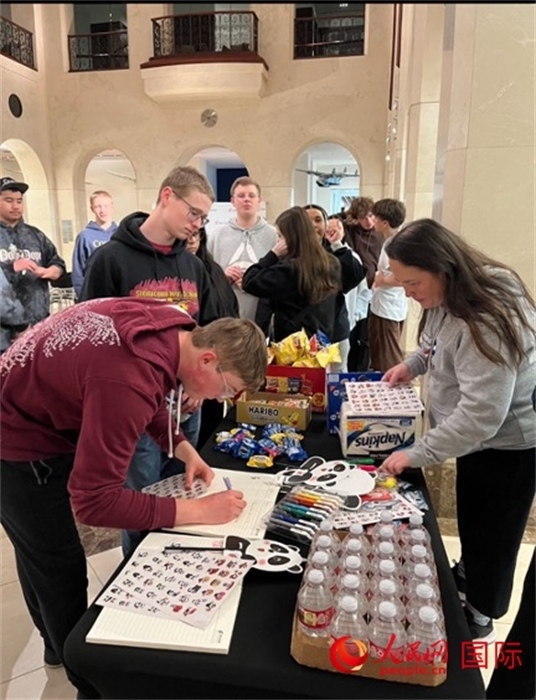 學(xué)生們出發(fā)前紛紛在留言簿留言。人民網(wǎng)記者 鄧圩攝