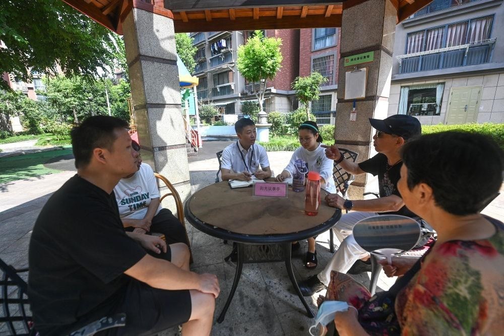 △2023年7月21日，在位于浙江杭州臨安區(qū)錦南街道水岸陽光小區(qū)的陽光議事廳，街道干部在聽取居民們反映的問題及意見。