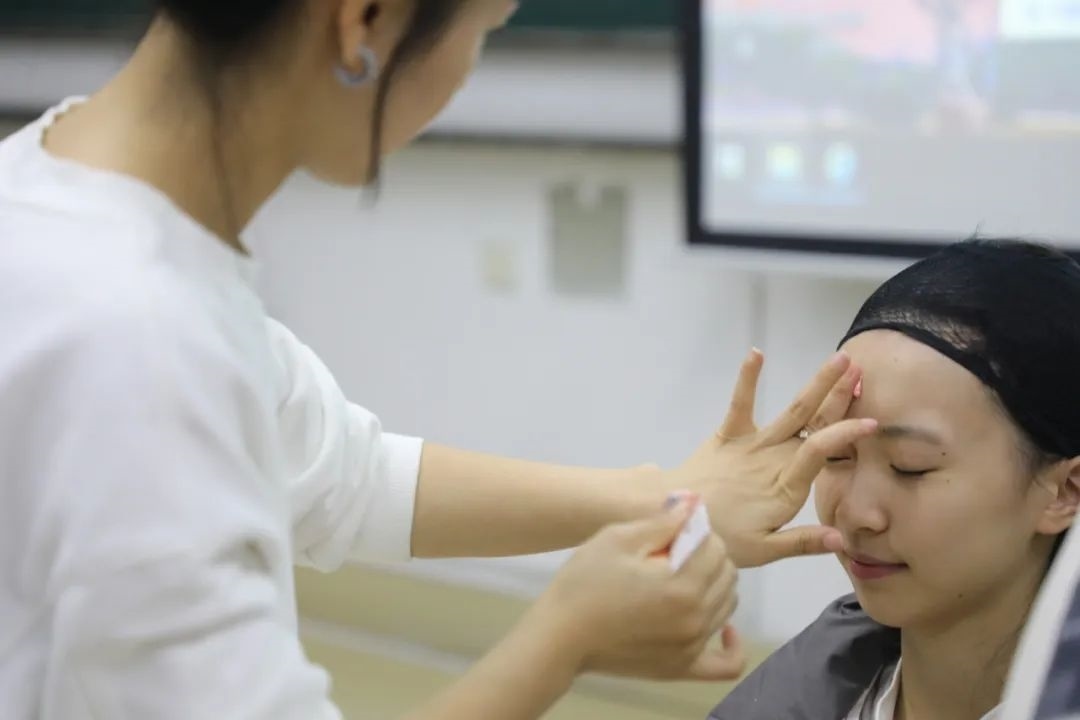 課堂上，一名學生在體驗上戲妝。學校供圖