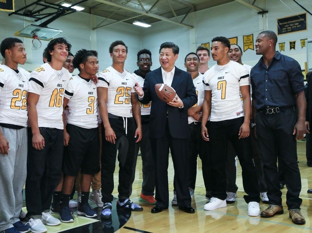 2015年9月23日，國(guó)家主席習(xí)近平參觀美國(guó)塔科馬市林肯中學(xué)。這是習(xí)近平在學(xué)校體育館，同上橄欖球訓(xùn)練課的學(xué)生們親切交談。新華社記者 蘭紅光 攝