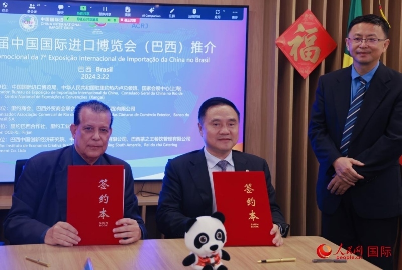 巴西外貿(mào)商會(huì)聯(lián)合會(huì)會(huì)長(zhǎng)阿代爾·羅伯托（左）與中國(guó)國(guó)際進(jìn)口博覽局副局長(zhǎng)吳政平（中）現(xiàn)場(chǎng)簽訂協(xié)議。人民網(wǎng)記者 宋亦然攝