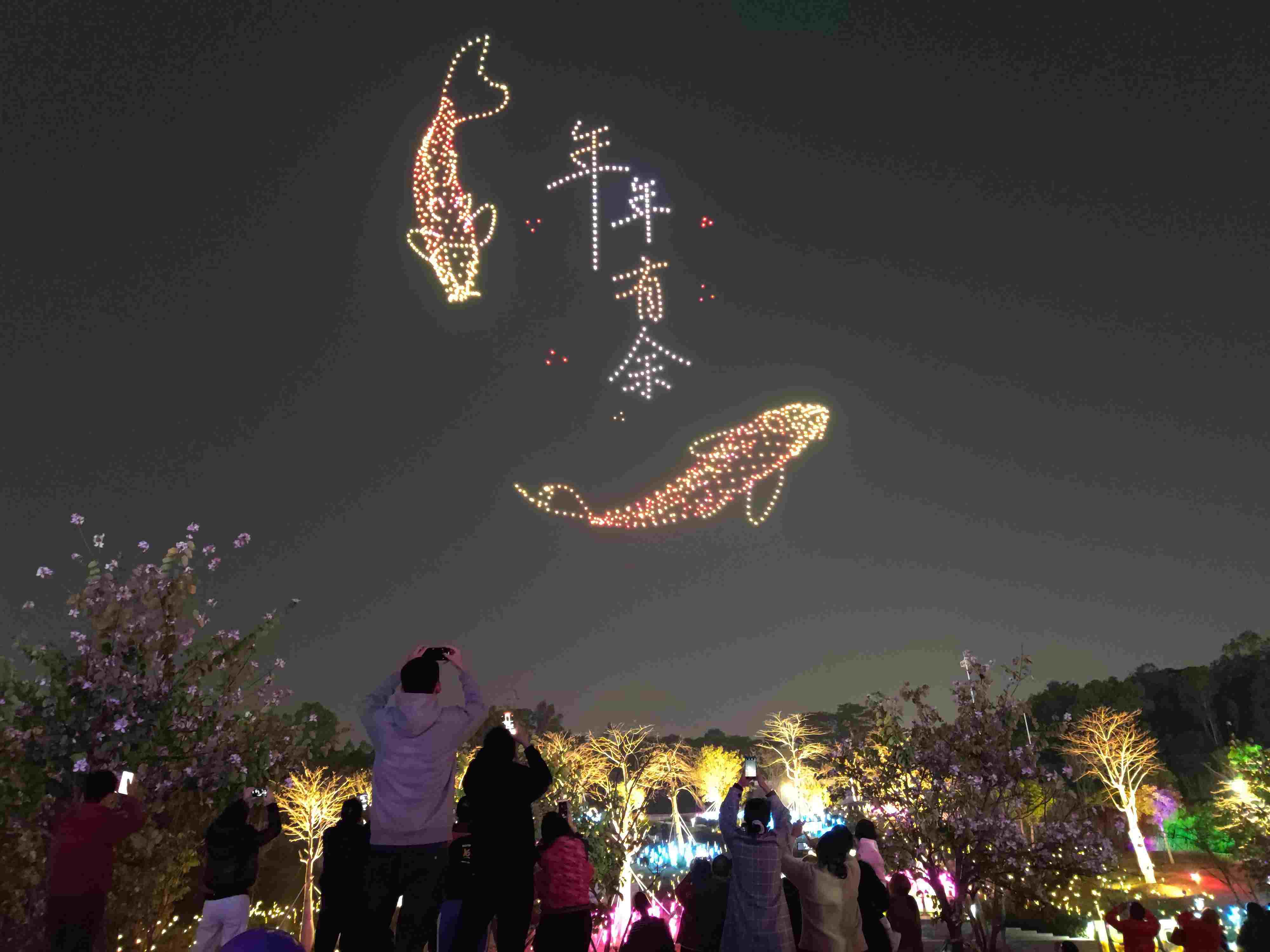△ 2024年2月10日，深圳北站中心公園，春節(jié)主題無人機(jī)燈光秀引來眾多游客駐足觀看。