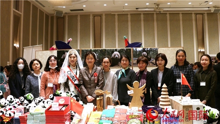 中國(guó)駐日本大使吳江浩夫人丁玥（左五）與使館人員在展位前合影留念。人民網(wǎng) 許可攝