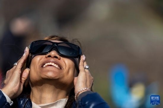 4月8日，一名女子在美國(guó)紐約州普拉茨堡觀看日食。新華社發(fā)（文森特·約翰遜攝）