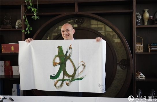 老撾駐華大使館三秘明君參加《五百筆·瀾湄合作》集體藝術創(chuàng)作。人民網(wǎng)王婧攝。