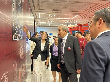 工作人員為泰國前副總理、泰中文化促進(jìn)委員會(huì)主席披尼講解展覽內(nèi)容。中國駐泰國大使館供圖