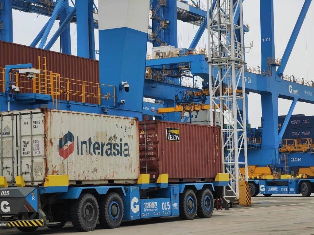 在欽州自動(dòng)化集裝箱碼頭，智能導(dǎo)引運(yùn)輸車在運(yùn)送集裝箱。新華社記者趙歡 攝