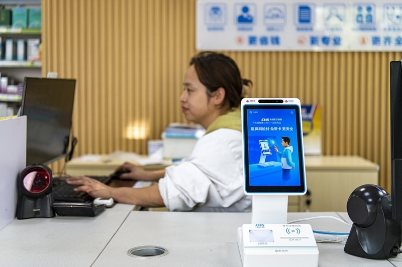 2024年4月10日，浙江金華市區(qū)一家民眾大藥房柜臺(tái)上設(shè)置著醫(yī)?！八⒛樦Ц丁睓C(jī)器，群眾看病更加便利。