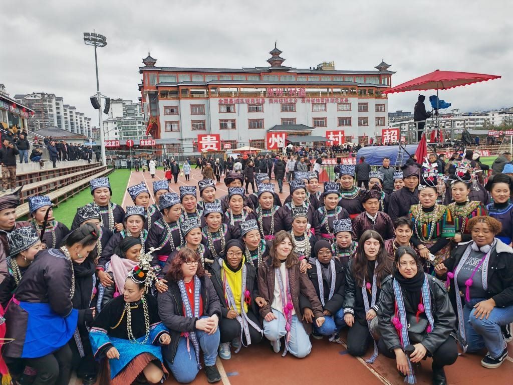 法國青年在“村超”賽場邊與參加表演的村民合影。新華社記者 羅羽 攝