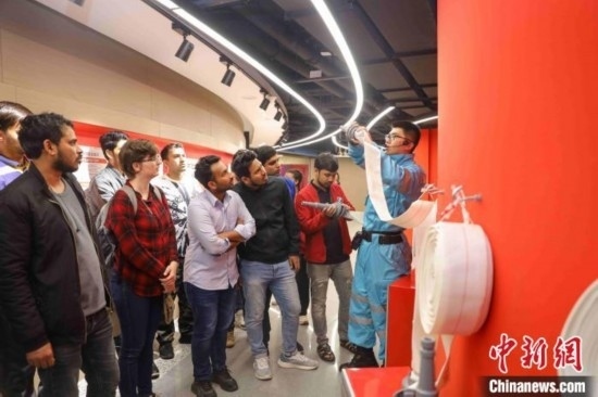 5月9日，工作人員指導(dǎo)留學(xué)生正確使用消防水帶。張鷹 攝