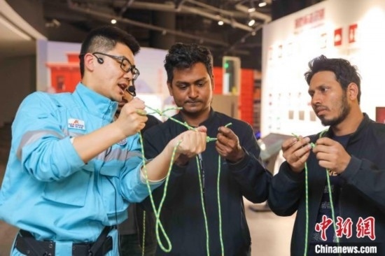 5月9日，工作人員指導(dǎo)留學(xué)生學(xué)習(xí)打繩結(jié)。張鷹 攝